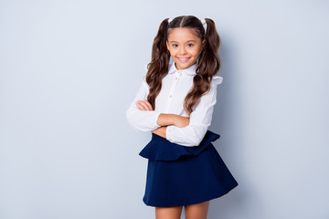 Sticker - Back to school! Nice cute tender cheerful adorable lovely stylish girl with curly pony-tails in white formal blouse and dark blue skirt, folded arms. Isolated over grey background