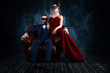 © Monstar Studio - Rich couple man male woman female in love sitting in leather sofa in expensive suit and red evening dress and black carnaval mask. Sex, tempts, harassment, sexism, seduction issues