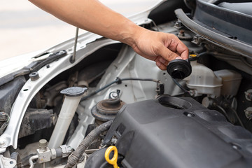 Man hand technician checking or fixing the engine of a modern car. Mechanic performing maintenance and car self fixing or maintenance.