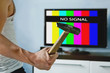 © diy13 - viewer is furious with the problems with broadcasting. Multi-colored stripes on the TV screen. The inscription on the TV NO SIGNAL. televiewer wants to smash the monitor with a hammer