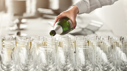 Wall Mural - Waiter pouring champagne into glasses at party