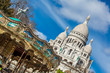 PARIS, FRANCE - MARCH, 2018: Carrousel and the Sacre Coeur Basilica at the Montmartre hill  in Paris France