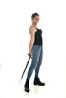 full length portrait of brunette girl wearing black single and jeans. standing pose holding a sword. isolated on white studio background.