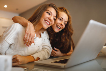 Sticker - Two young women online via a laptop in the living room