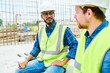 © Seventyfour - Portrait of two workers wearing hardhats  chatting during coffee break on construction site
