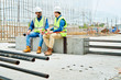 © Seventyfour - Full length portrait of two workers wearing hardhats  chatting while enjoying coffee break on construction site