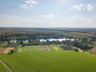 Wall Mural - Amazing countryscape with green fields, river, greenery and blue cloudy sky in a summer time.