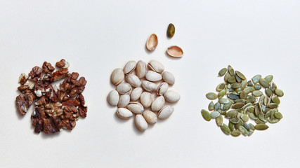 Wall Mural - Mix of assorted natural nuts - pistachios, walnuts, pumpkin seed . Organic natural pattern on a white background.