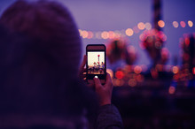 Woman Taking Pictures Of European Christmas Market Scene On Smartphone