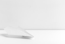 Flat Lay Of White Paper Plane On White Color Background