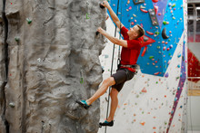 Photo From Side Of Young Sports Male Exercising On Climbing Wall