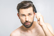 © denis_vermenko - Portrait of handsome young man combing his hair in bathroom. Isolated over grey background.