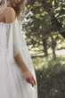© LIGHTFIELD STUDIOS - cropped shot of young bride in wedding dress holding cigarette outdoors