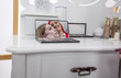 © StockVideoFactory - A make up artist and her client are looking themselves in a small mirrow which is standing on a make up table.