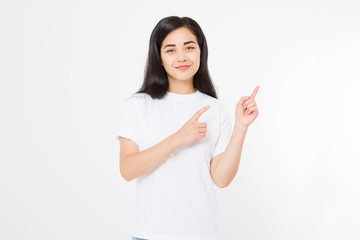 Wall Mural - Portrait of smiling young asian woman wearing summer t shirt pointing at copy space by finger isolated on white template and blank background.