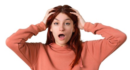 Young redhead girl with pink sweatshirt with surprise and shocked facial expression. Gaping because can not believe what is happening on isolated white background