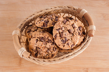 Up view on basket with cookies on wooden background