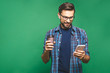 © denis_vermenko - Portrait of happy young man talking on phone and drinking tea. Isolated over green background.