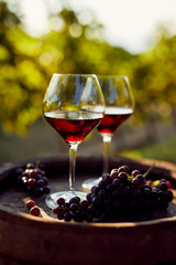 Two glasses of red wine on a wooden barrel