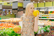 Attractive blonde nutritionist with melons at grocery store