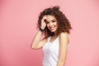 © opolja - Image of happy young lady standing isolated over pink background. Looking camera pointing.