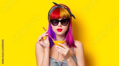 Cuadros en Lienzo Young girl with purple hair holding lemonade cocktail on yellow background