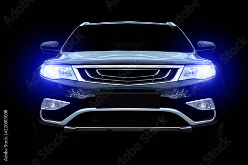 Fényképezés  The car on a black background with shallow depth of field shines with headlights