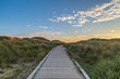 A wooden pathway leading towards the sea at Formby in Merseyside, taken at sunset