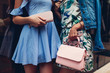 © maryviolet - Two young beautiful women wearing stylish clothes and accessories. Girls holding purse and handbag. Summer outfit