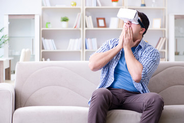 Man with virtual reality glasses playing at home