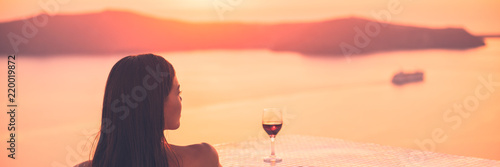 Luxury travel woman drinking red wine glass watching sunset on cruise ship holiday vacation - rich people high end lifestyle banner panorama landscape.