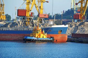 Tugboat assisting bulk cargo ship