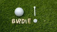 Golf Birdie With Tee And Marker On Green Grass