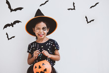Happy Asian Little Child Girl In Costumes And Makeup Having Fun On Halloween Celebration