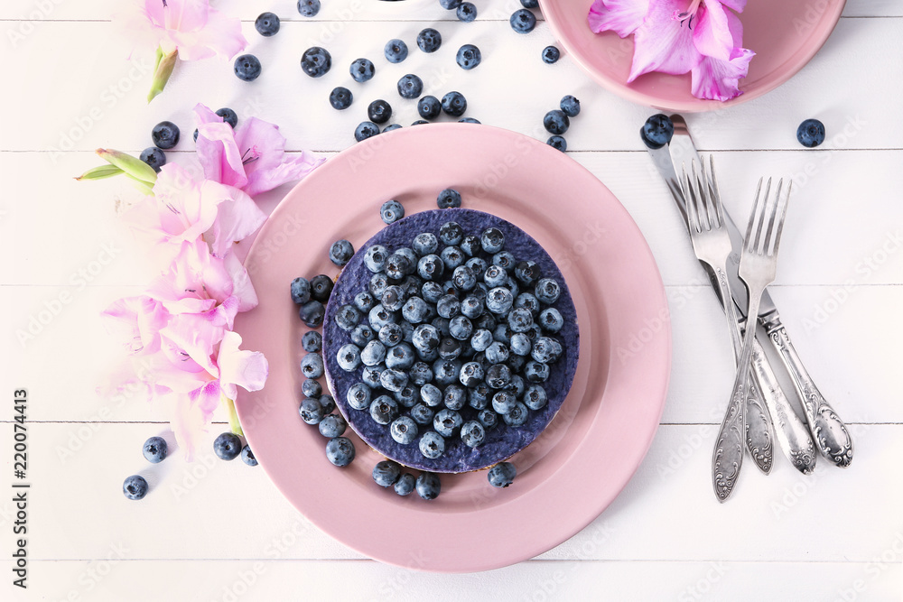 Plate with delicious blueberry cheesecake on table