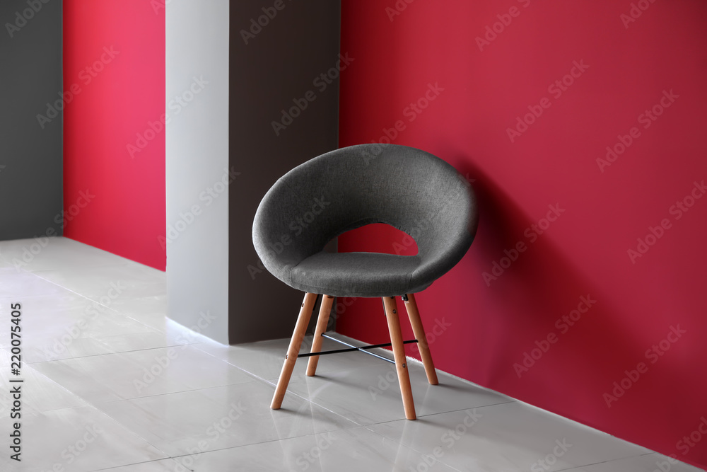 Comfortable chair near color wall