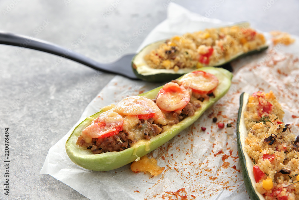 Meat and quinoa stuffed zucchini boats on light table