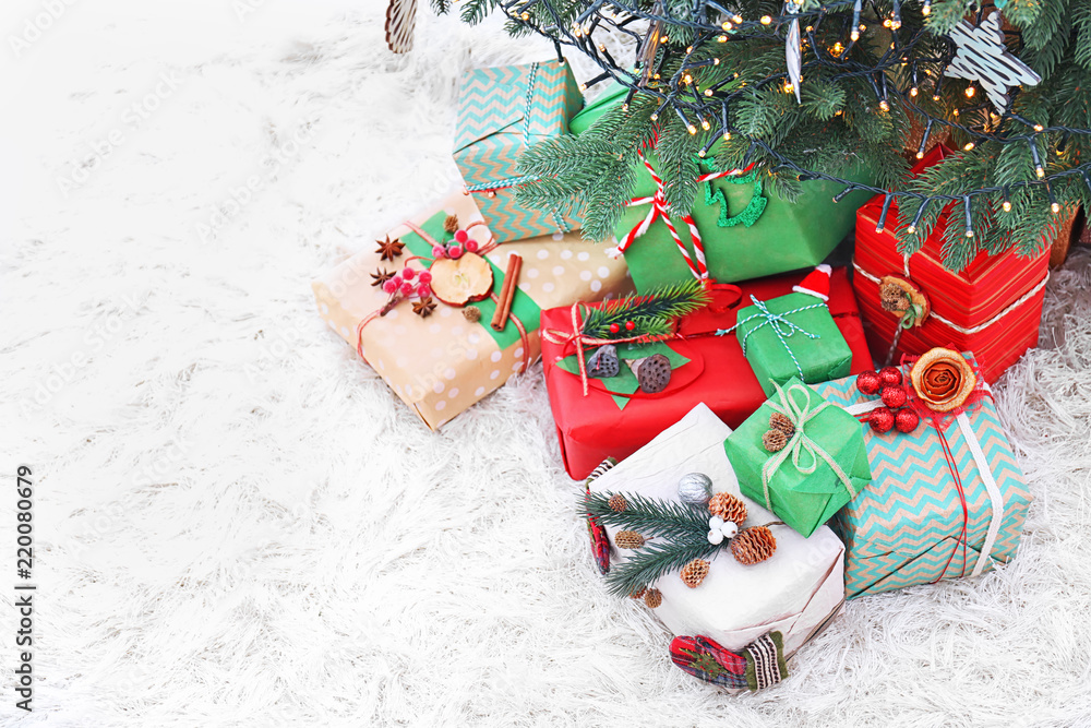 Many Christmas gifts on floor under fir tree