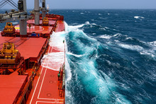 Cargo Ship Rolling In Stormy Sea. Huge Waves Under Blue Sky In Indian Ocean