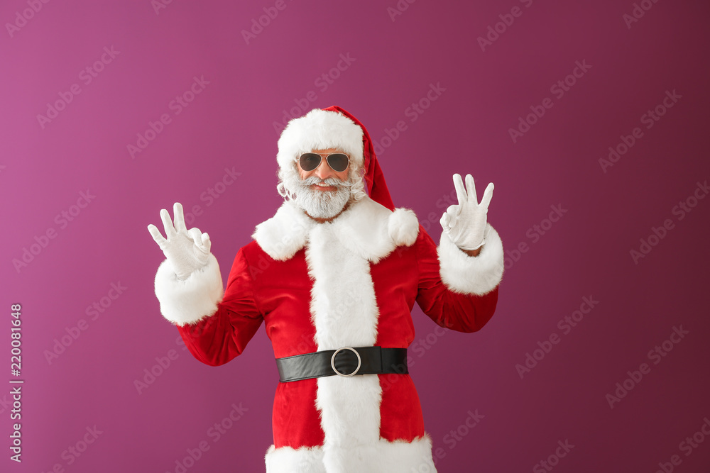 Cool Santa Claus showing OK gesture on color background