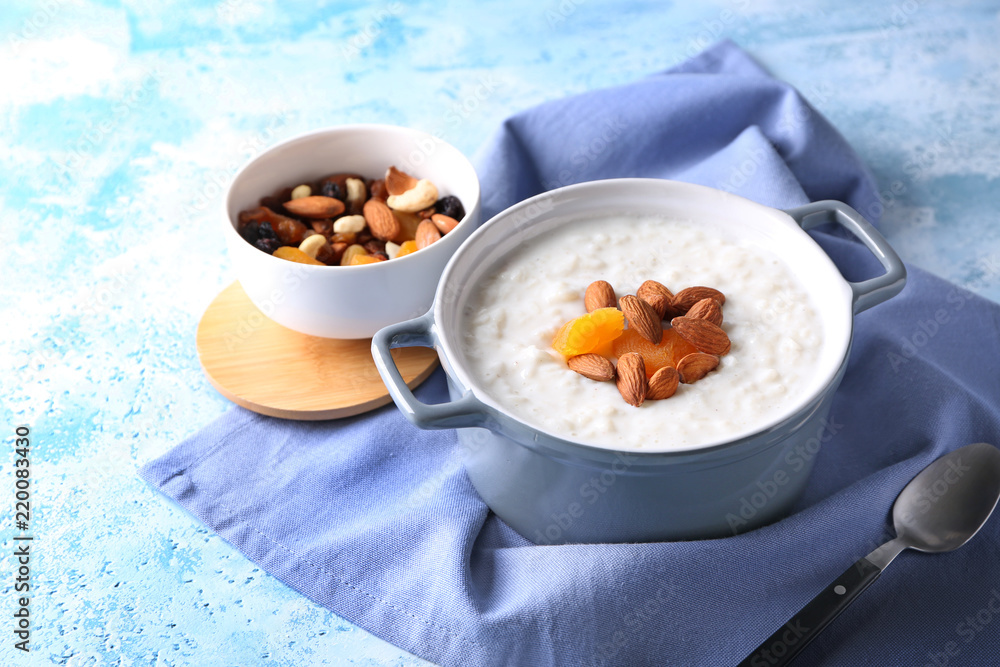 Delicious rice pudding with dried apricots and almonds in casserole on table