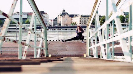 Sticker - Beautiful young woman stretching on the bridge in the city.