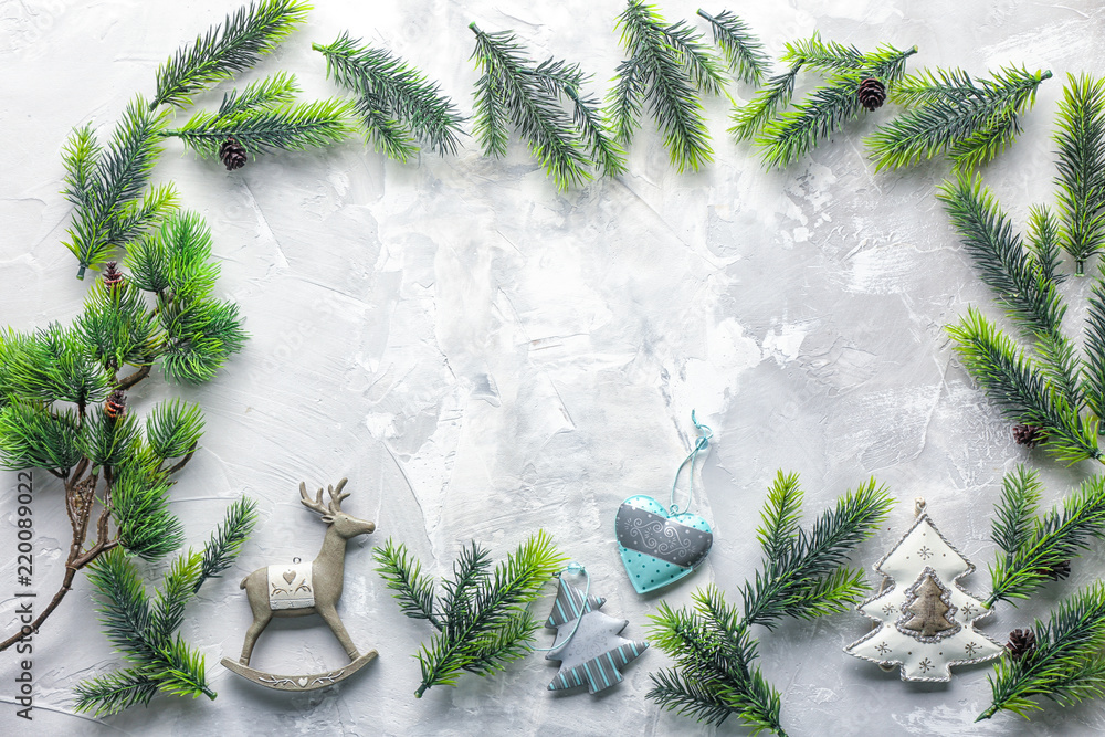 Frame made of fir tree branches and Christmas decorations on light background