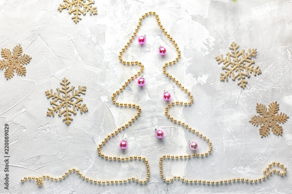 Beads in shape of Christmas tree with decorations on light background