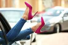 Young Woman With Slim Legs In High Heels Relaxing In Car