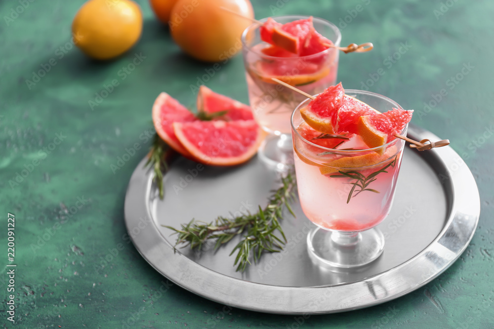 Fresh grapefruit cocktail with rosemary in glasses on metal tray