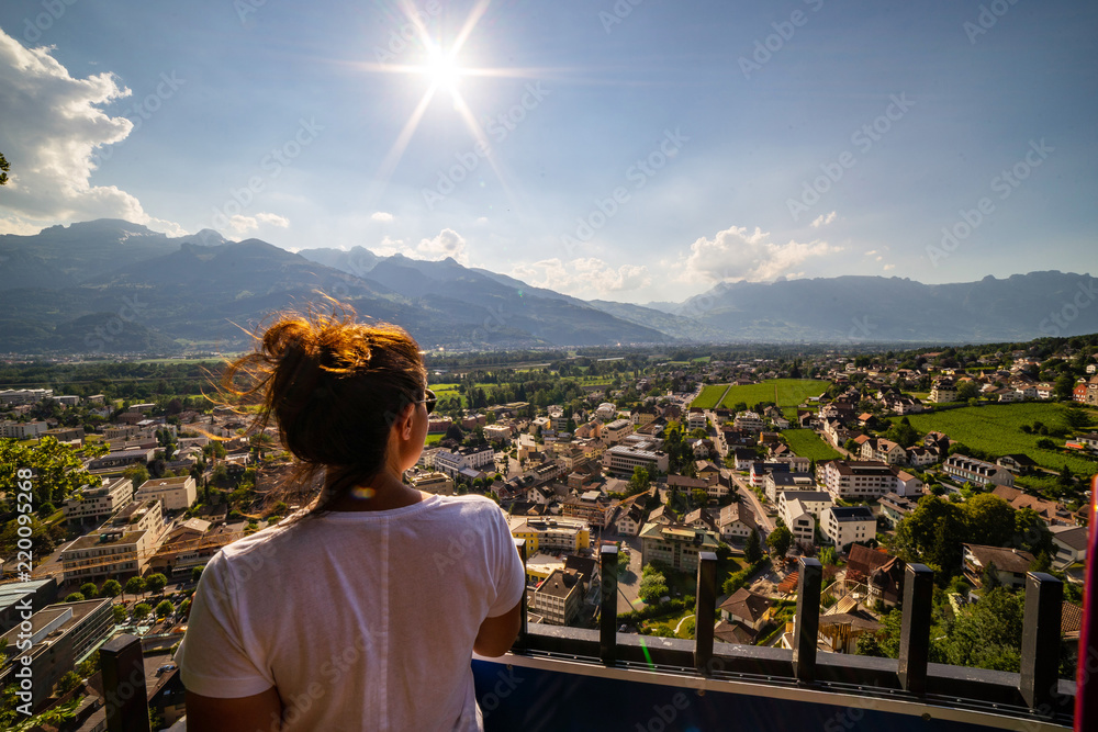 Obraz na płótnie Female tourist admiring view of Vaduz, Liechtenstein. Vaduz is the capital of Liechtenstein and also the seat of the national parliament. w salonie