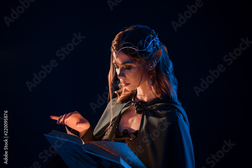 Side View Of Mystic Female Beatiful Elf Reading Magical Book In Darkness Stock Photo Adobe Stock