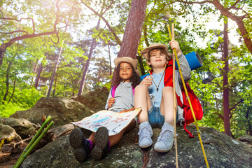 Kids rest during hike boy and girl with map