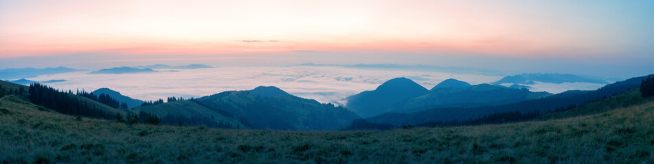 Wall Mural - waves of clouds over the mountains in the morning